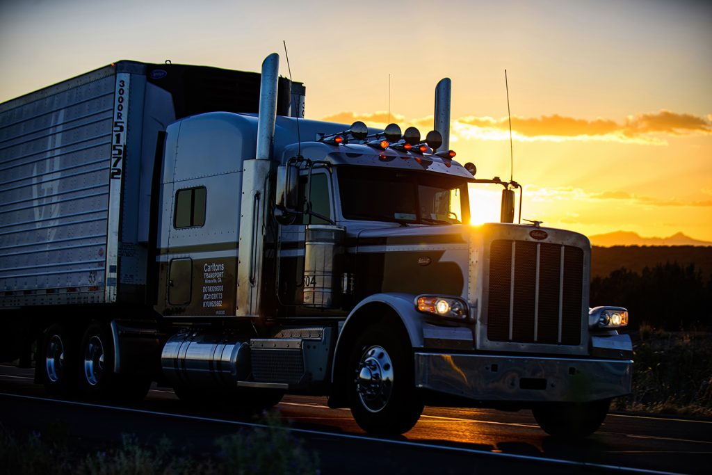 American semi truck driving at sunset